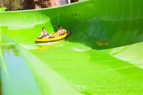 Two Young Girls Having Fun On Vacation On A Slide In Water Park Sharm