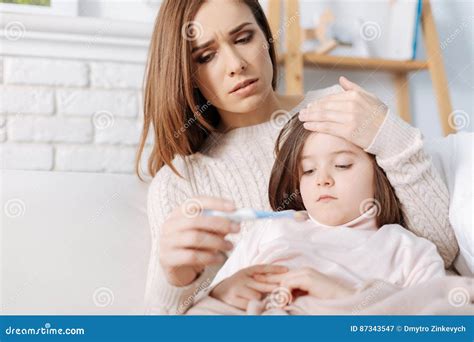 Madre Cariñosa Preocupada Que Toma Cuidado De Su Hija Enferma Imagen De