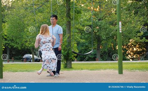 active asian man swings his pregnant wife on a swing activity during pregnancy stock footage