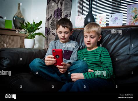 2 Boys 8 9 10 11 Playing A Computer Game On Mobile Phonesitting On