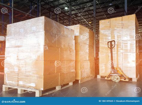 Stack Of Shipments Boxes On Wooden Pallets And Electric Forklift Pallet Jack At The Warehouse