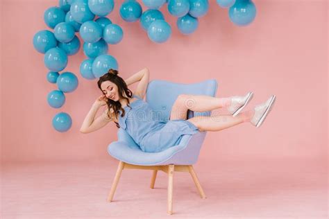 Girl In A Blue Dress In A Pink Room With A Blue Chair And Blue B Stock