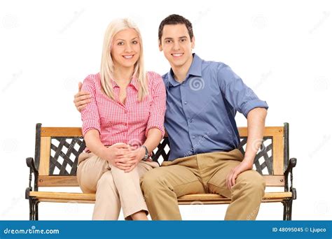 Cheerful Young Couple Posing Seated On A Bench Stock Image Image Of