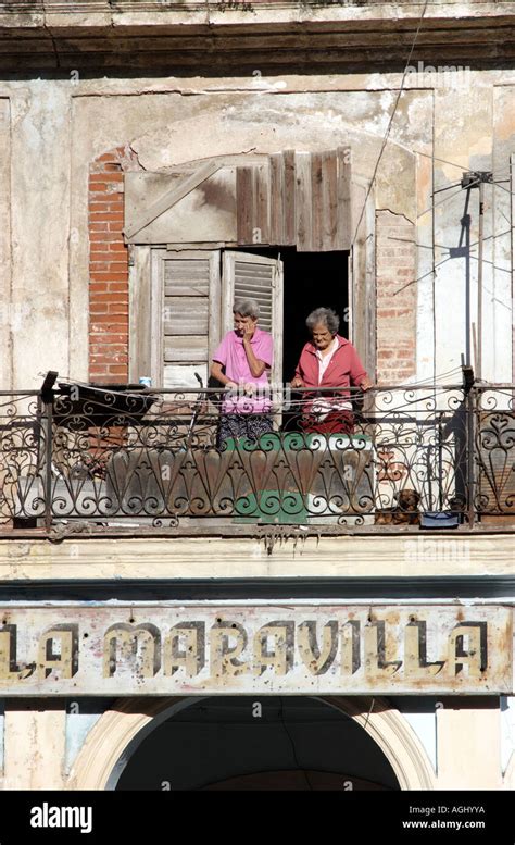 Two Cuban Women Watching The World From A Dilapidated Balcony In Plaza
