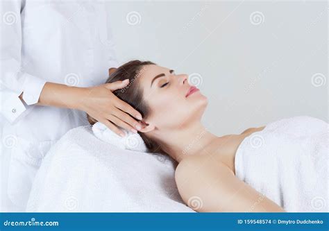 Masseur Makes A Relaxing Massage On The Face Neck And Shoulders Of A