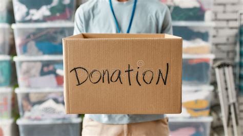 Close Up Of Box For Donation Young Man Volunteer Holding Cardboard Box