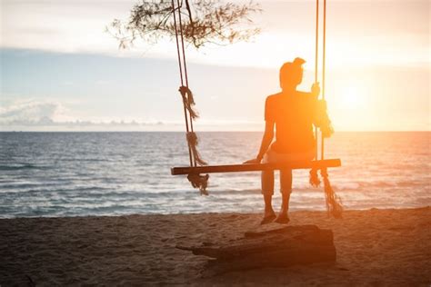 Mujer Joven Viendo Puesta De Sol Solo Sentado En Columpios En La Playa