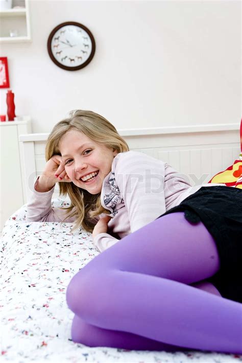 a smiling teenage girl lying on her bed stock image colourbox