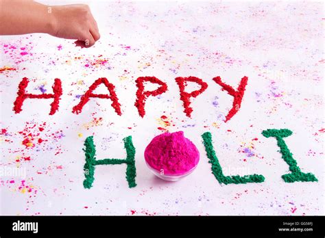 Hand Writing Happy Holi With Gulal Over White Background Stock Photo
