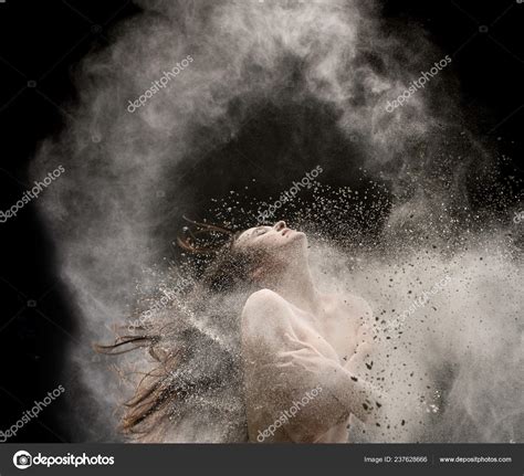 Femme nue dans un nuage de poussière blanche dans l obscurité image