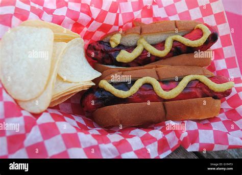Two Takeout Red Hot Dogs Served With Mustard And Potato Chips Stock Photo