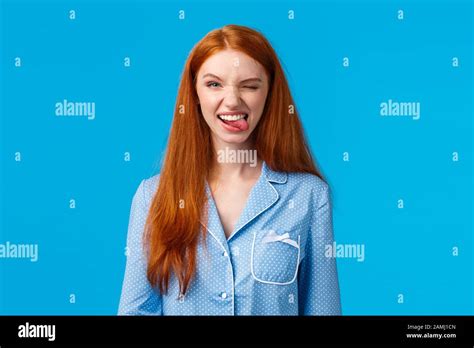Sassy And Excited Good Looking Redhead Female In Nightwear Winking Joyfully And Smiling Camera
