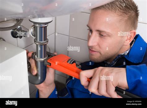 Male Plumber Fixing Sink In Kitchen Stock Photo Alamy