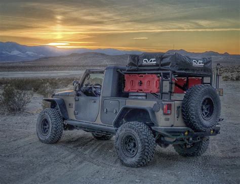 The Jeep Is Parked In The Desert At Sunset