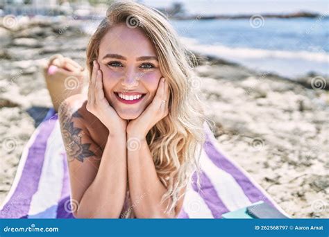Young Blonde Girl Wearing Bikini Lying On The Towel At The Beach Stock