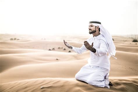 Arabic Man With Traditional Emirates Clothes Walking In The Desert