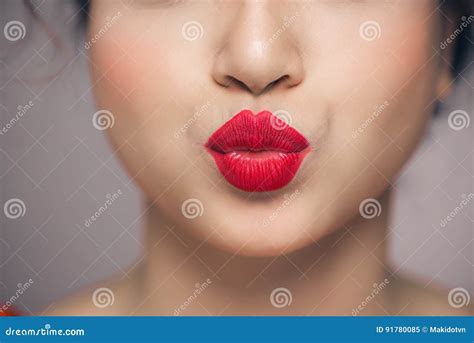 Woman`s Lips Blowing A Kiss With Bright Red Lipstick Stock Image