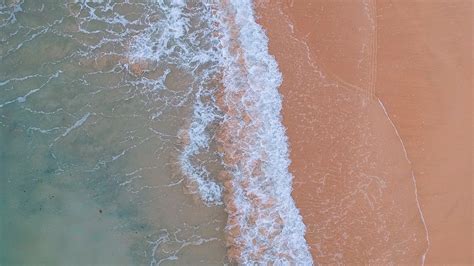 Download Wallpaper 1366x768 Ocean Aerial View Water Sand Foam