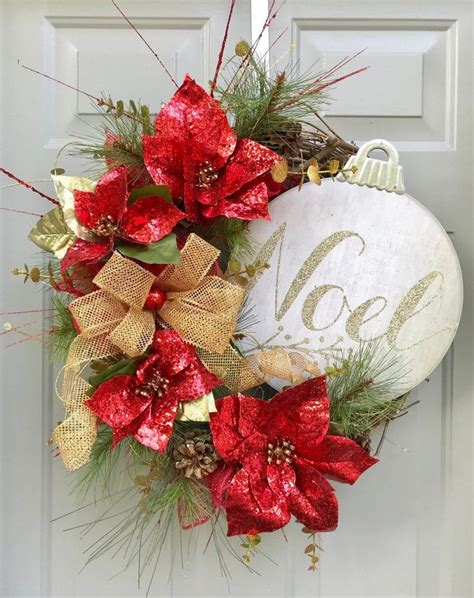 A Red And Gold Christmas Wreath With Poinsettis Hanging On The Front Door