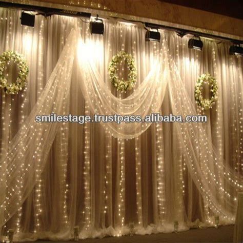 The Curtain Is Decorated With Lights And Wreaths