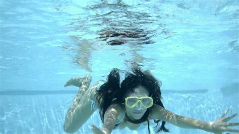 Underwater Woman Swimming With Arms Outstretched In Bikini And Goggles At Pool With Clear Water