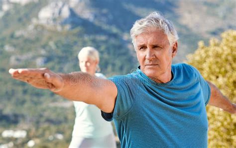 Seniors Living A Healthy Lifestyle And Exercising Outdoors Senior Couple Standing In Warrior