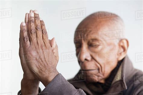 Older Black Man Praying With Hands Clasped Stock Photo Dissolve