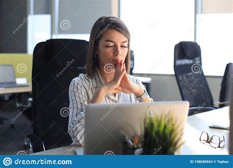 Calm Beautiful Businesswoman Meditating In Office With Eyes Closed