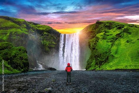 Skogafoss Waterfall In Iceland Guy In Red Jacket Looks At Skogafoss