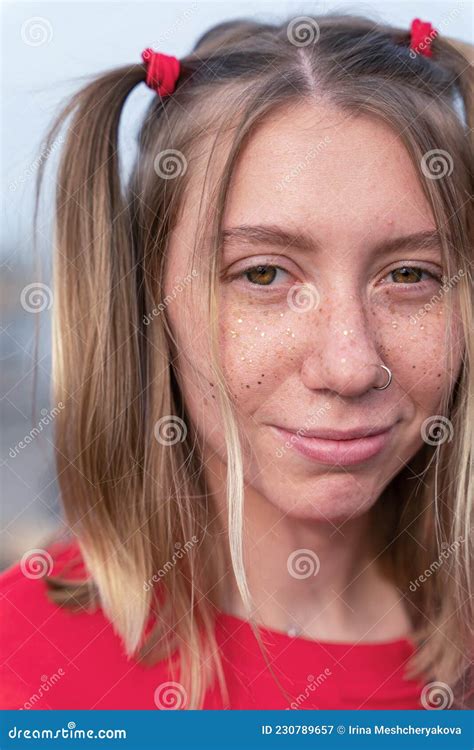 retrato vertical de una joven rubia sonriente con una cara conmovedora y juguetona pecas en la