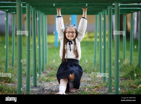 Portrait Of Beautiful Young Girl On The Playground Arms Hi Res Stock