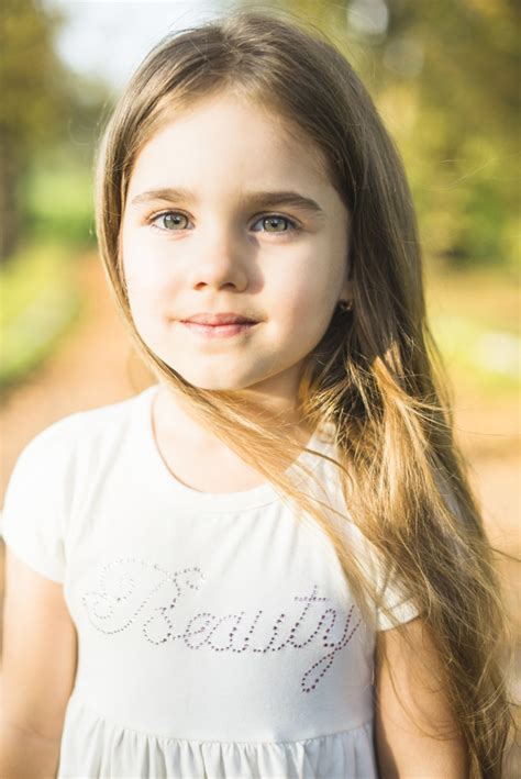 Little girl smile with long blond hair. Cute little girl with long hair in white dress | Free Photo