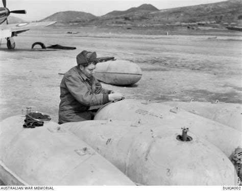 An Unidentified 77 Squadron Raaf Armourer Filling Napalm Drop Tanks For