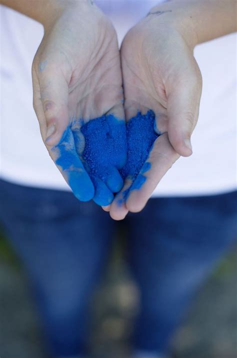 A Person Holding Blue Powder In Their Hands