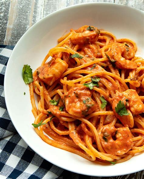 Pasta With Shrimp And Tomato Sauce In A White Bowl On A Checkered Tablecloth