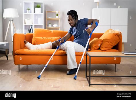 Man With Broken Leg After Accident Using Crutches Stock Photo Alamy