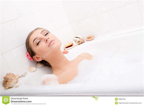 Relaxing Attractive Young Woman Lying In The Bath With Foam Enjoying Spa Relaxation Treatment