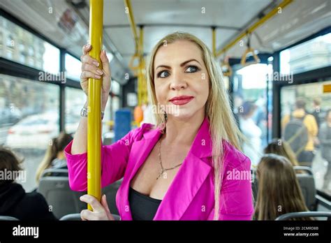 Middle Aged Woman In Pink Is Standing In The Bus And Holding The Handrail Caucasian Mature
