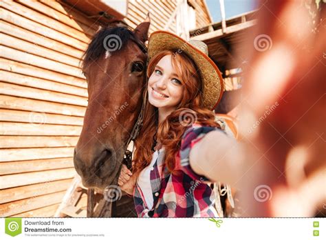 Rozochocona Kobiety Cowgirl Pozycja Bierze Selfie Z Koniem Na Gospodarstwie Rolnym Zdjęcie Stock