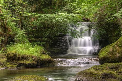 Stunning Waterfall Flowing Over Rocks Through Lush Green Forest