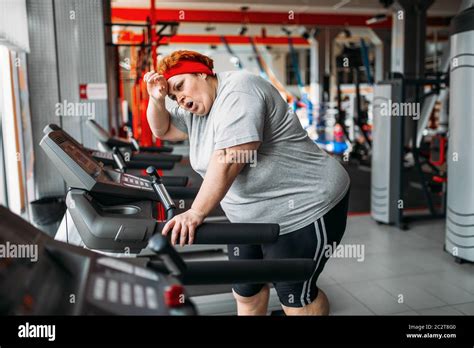 Overweight Tired Woman Running On A Treadmill In Gym Calories Burning