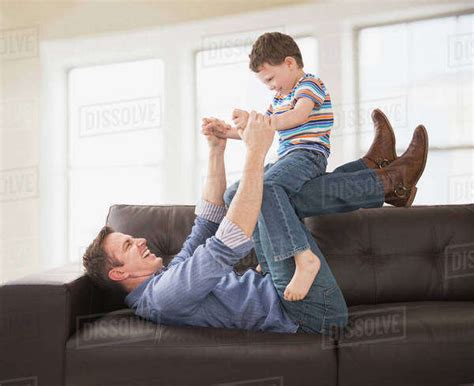 Caucasian Father And Son Playing On Sofa Stock Photo Dissolve
