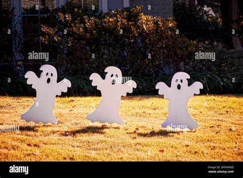 Halloween Decorations Three Cut Out Ghosts Dance In Autumn Yard Stock