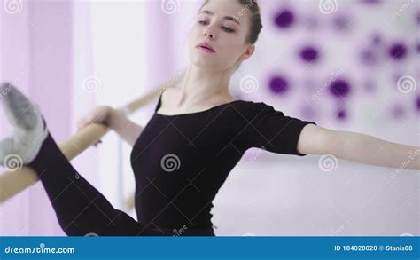 Young Thin Ballerina In Black Dress Dancing Or Stretching Near A Big