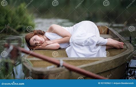 Ritratto Della Giovane Donna Graziosa Che Si Trova Nella Barca Sulla Sponda Del Fiume Fotografia