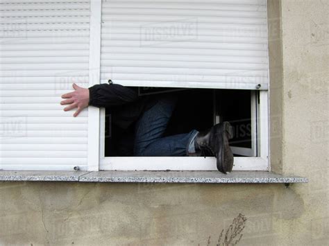 A Man Climbing Through A Window Stock Photo Dissolve