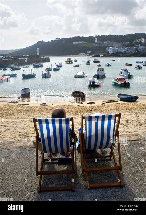 Holidaymakers Sitting In Deckchairs Overlooking St Ives Harbour In Cornwall Stock Photo Alamy