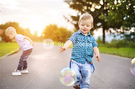 Cute Little Boys Playing And Having Fun Outside On A Street Royalty