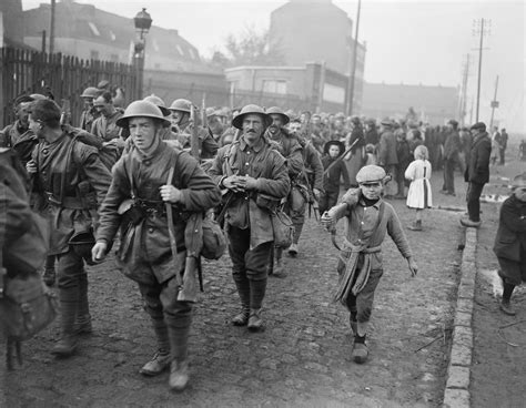 A Boy Walks Alongside British Troops Marching Through Lille After Its