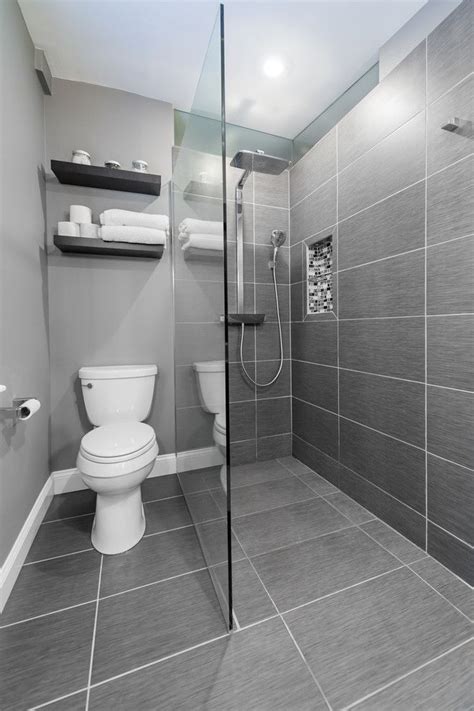 Designing a small bathroom means you'll have to be clever and purposeful with every decision, and your bathroom's tile is one of the first things you'll notice when you step into the room. small bathroom with grey flooring, grey tiles in shower ...